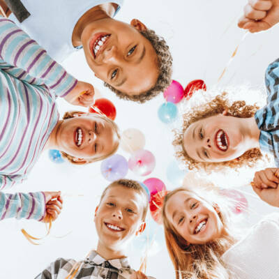 Group of happy children holding balloons and having fun
